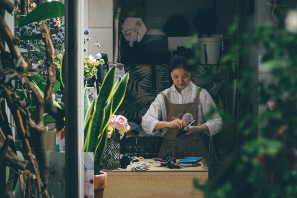 Small business owner, florist, in shoppe surrounded by greenery.